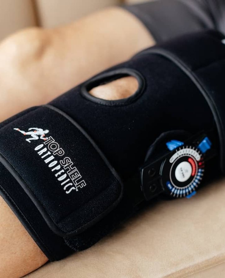 Athletic woman adjusting a blue knee brace